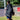 Person carrying a black backpack with 'nuk' branding on a grassy field.